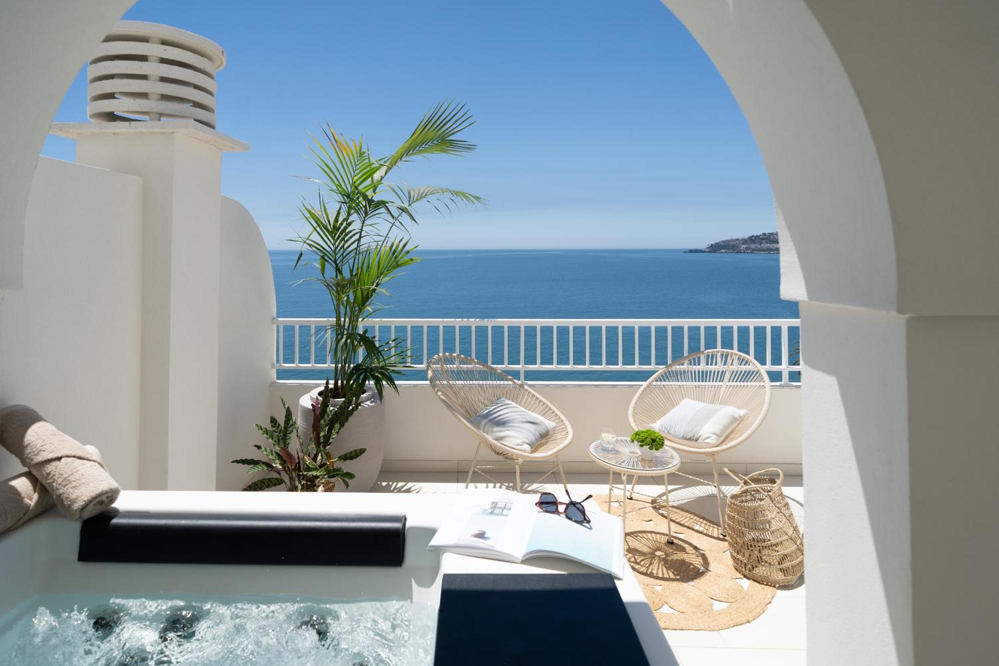Sala panorámica con vistas al mar y bañera de hidromasaje en la terraza